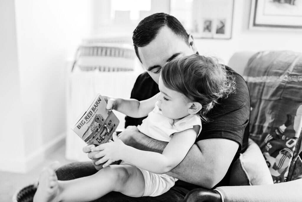 Dad reading Big Red Barn by Margaret Wise Brown to his little boy.