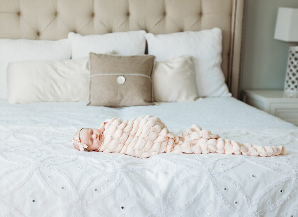 Newborn baby portrait taken by a DC Newborn Photographer on her parents' bed.
