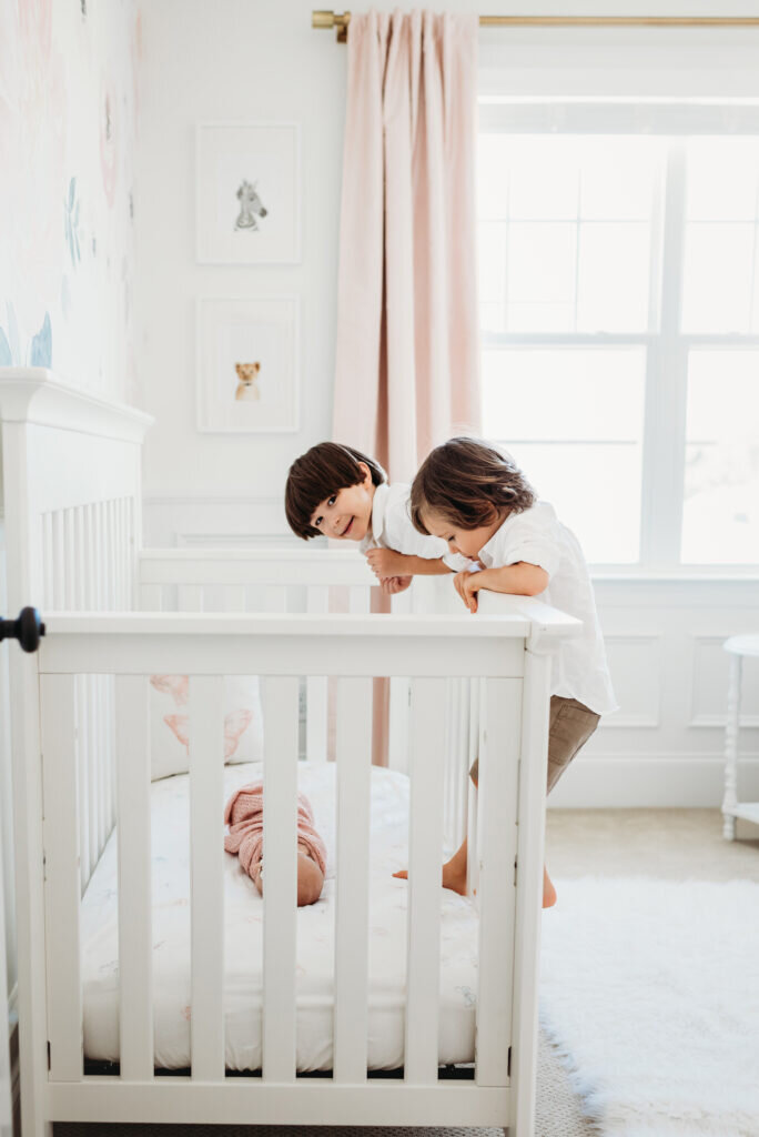 DC Lifestyle Newborn Photographer captures REAL like big brothers climbing on crib to see their new sister.