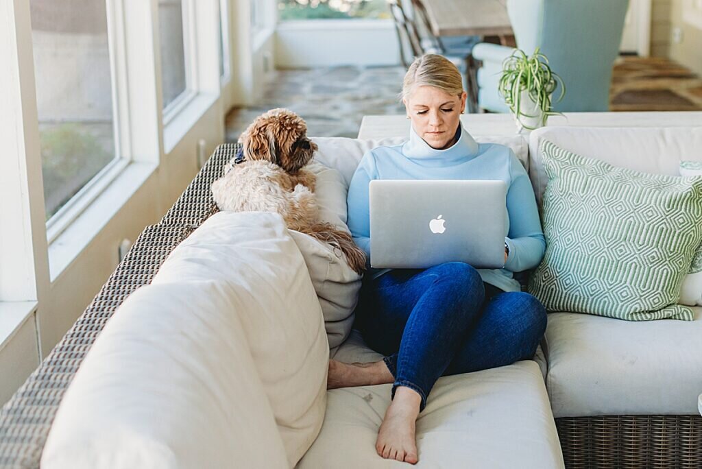 Natasha Sewell working on Macbook with dog next to her