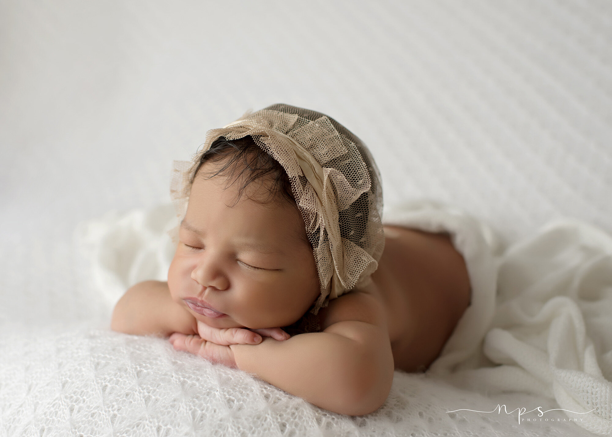 head in hands newborn pose with gold bonnet 