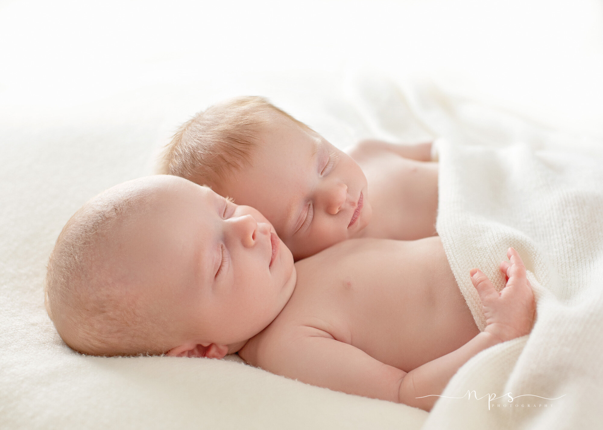 newborn twins snuggling