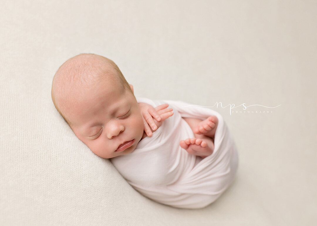 newborn blanket pose with feet showing