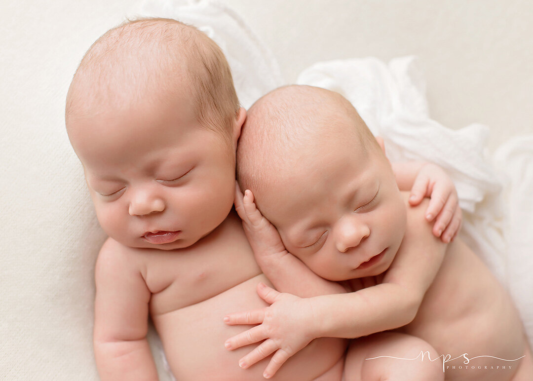newborn twins snuggling