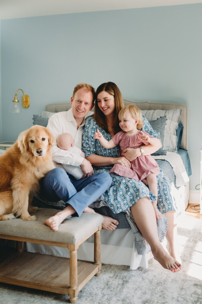 family of four sitting on bed with their dog photographed by NPS Photography