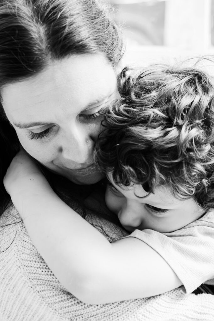 mom hugging little boy with curly hair photographed by NPS Photography