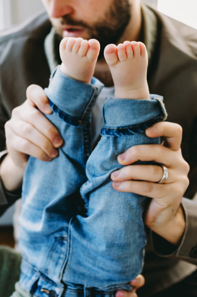 dad holding toddler upside down close-up of feet