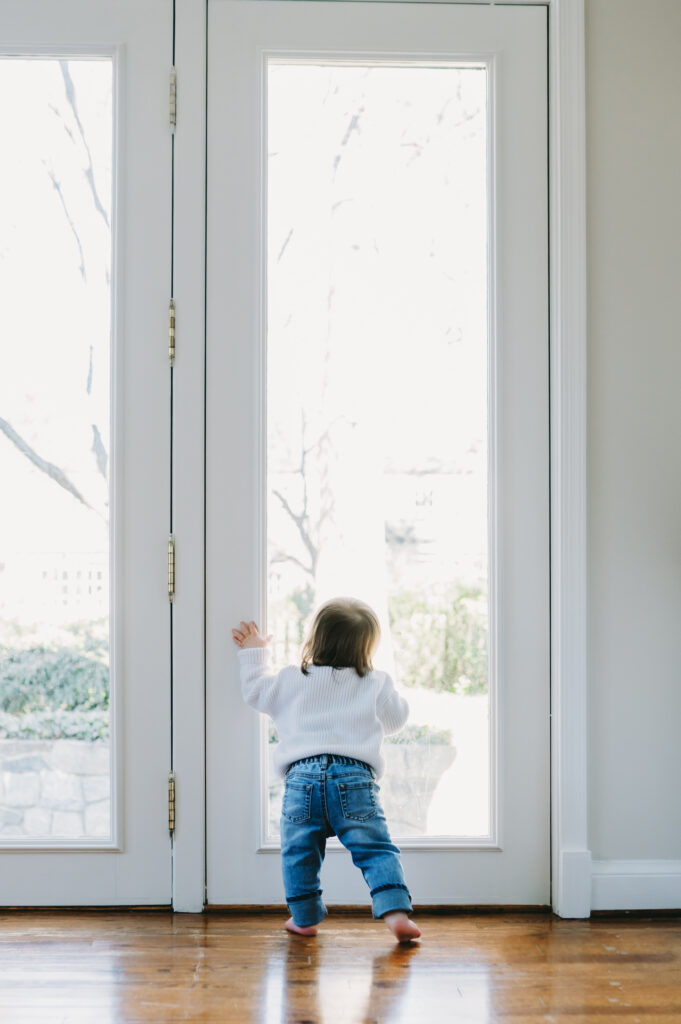 toddler looking out glass doors