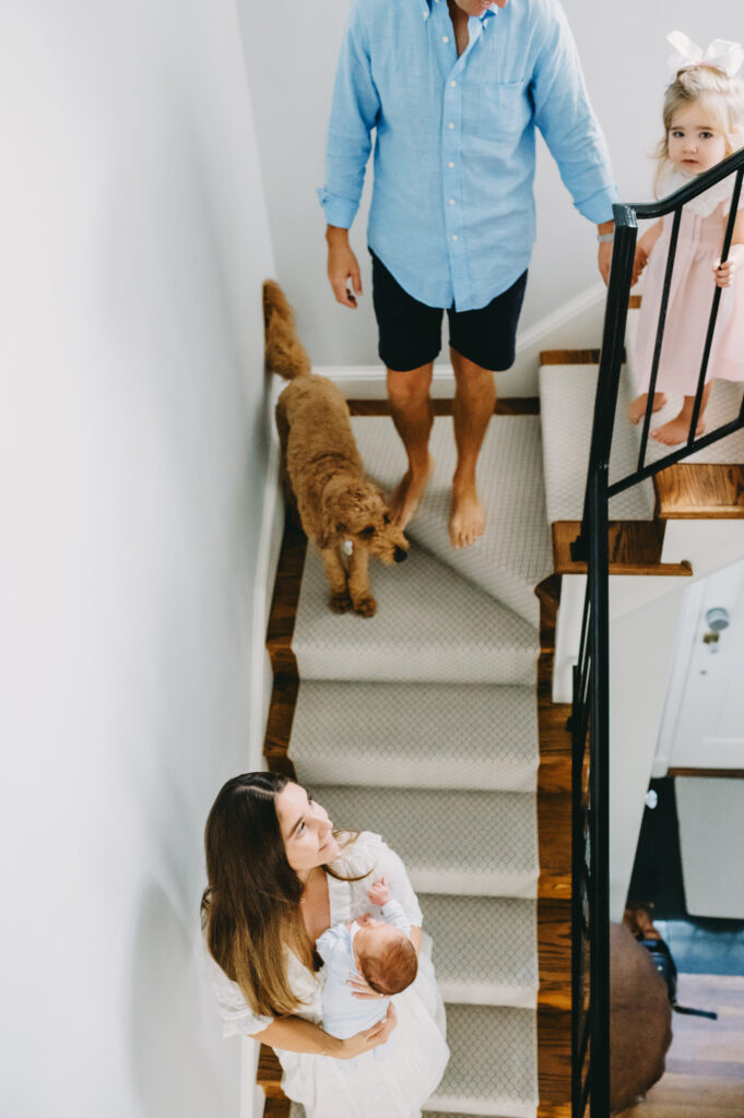 family with dog walking down the stairs