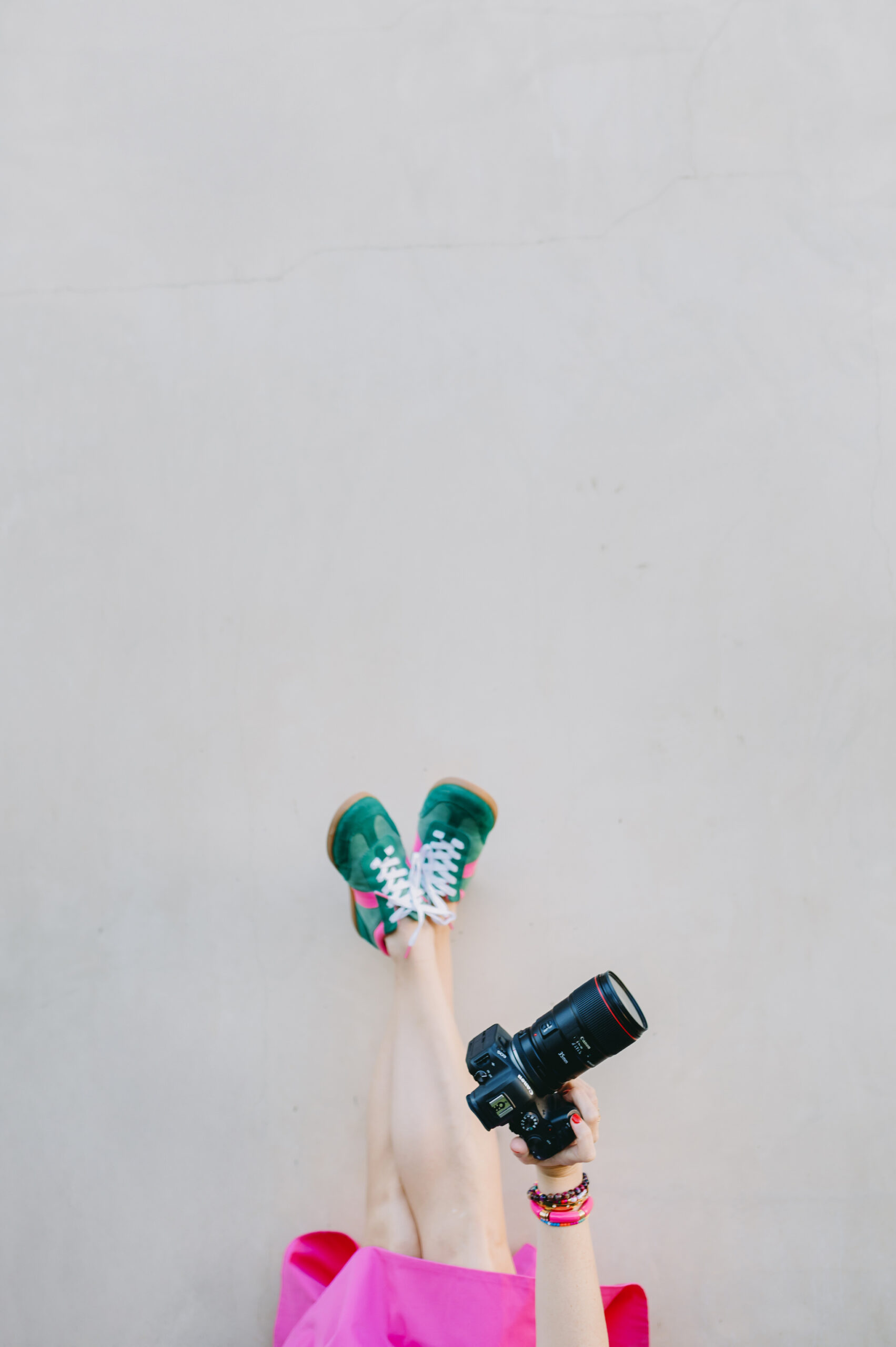 woman-holding-sneakers-and-camera