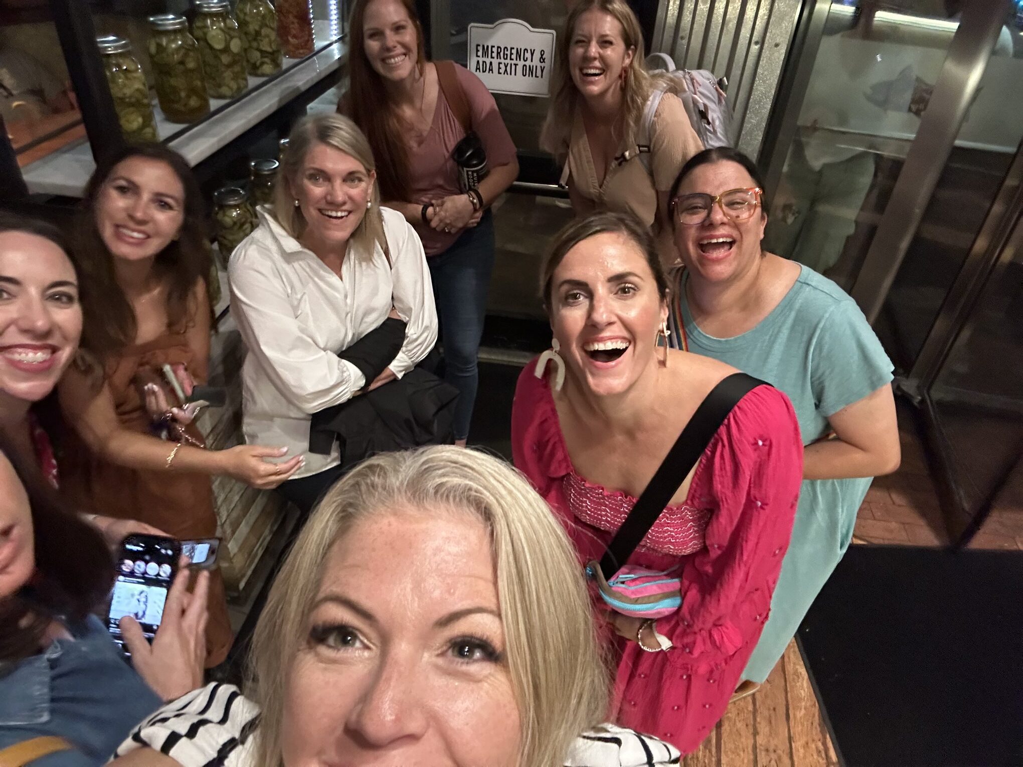attending-a-photography-retreat A joyful group of women smiling for a selfie, capturing connection and fun while attending a photograph retreat