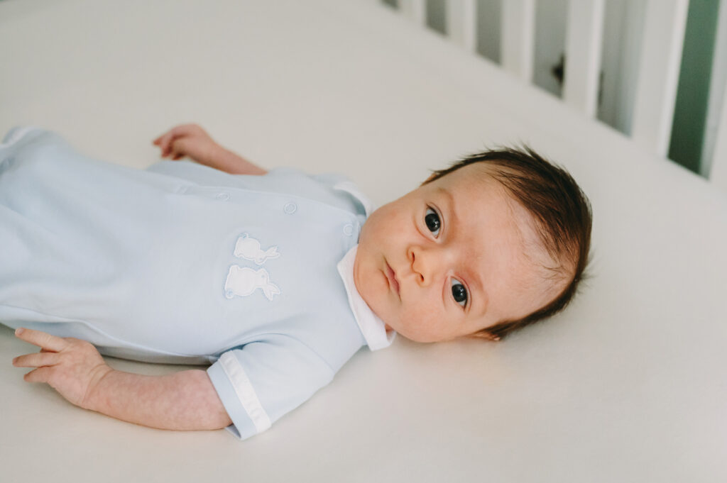 Luxury Family Photographer Pricing: You Are Not Your Client’s Budget Coach - NPS Photography wide awake newborn baby in a crib - McLean, VA photographer