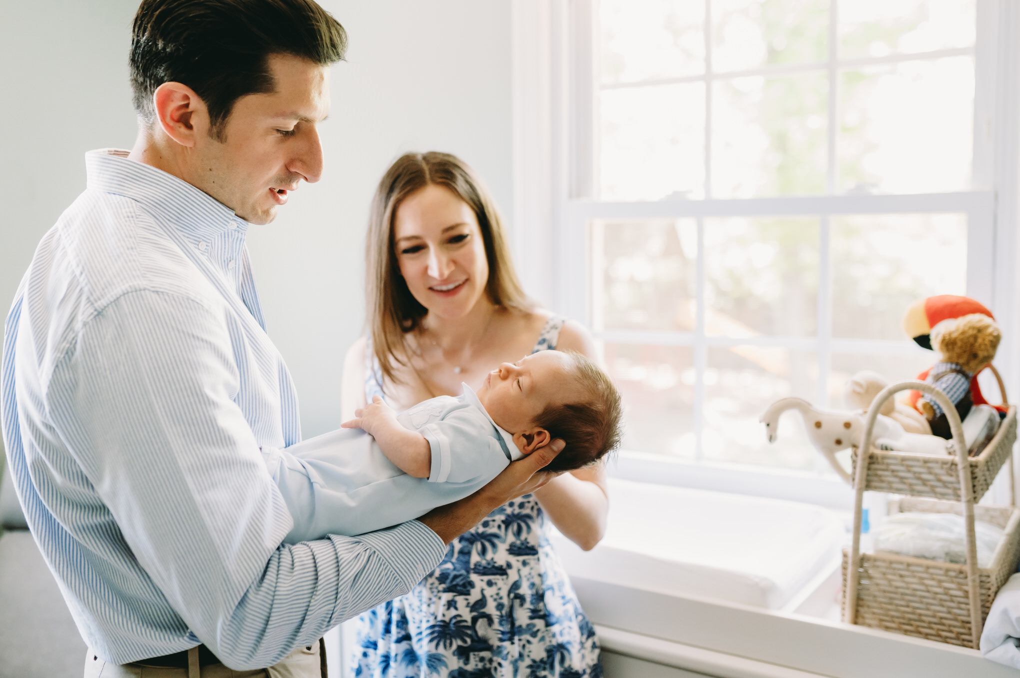 Luxury Family Photographer Pricing: You Are Not Your Client’s Budget Coach - NPS Photography dad holding newborn baby with mom looking on traditional home mclean, va