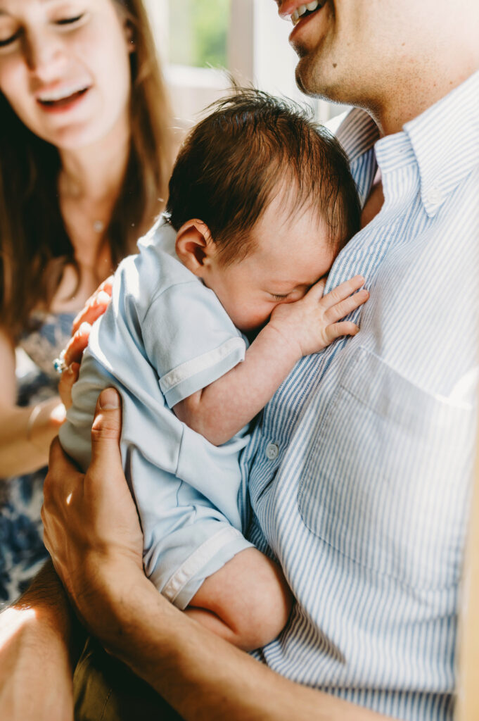 Luxury Family Photographer Pricing: You Are Not Your Client’s Budget Coach - NPS Photography newborn baby boy curled up in dads arms