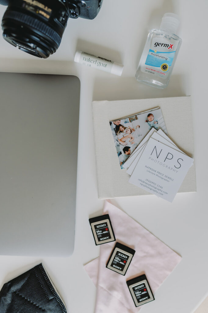 Email Like a Pro: Using AI to Save Time and Strengthen Client Prep as a Photographer - NPS Photography Flat lay of a photographer’s essentials—including gear and branded materials—ready to email like a pro and prep clients with care.