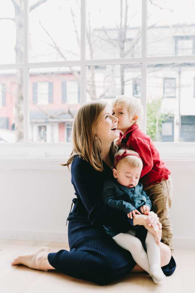 photography-prompts-for-kids A loving mom shares a joyful moment with her two young children using gentle photography prompts for kids.