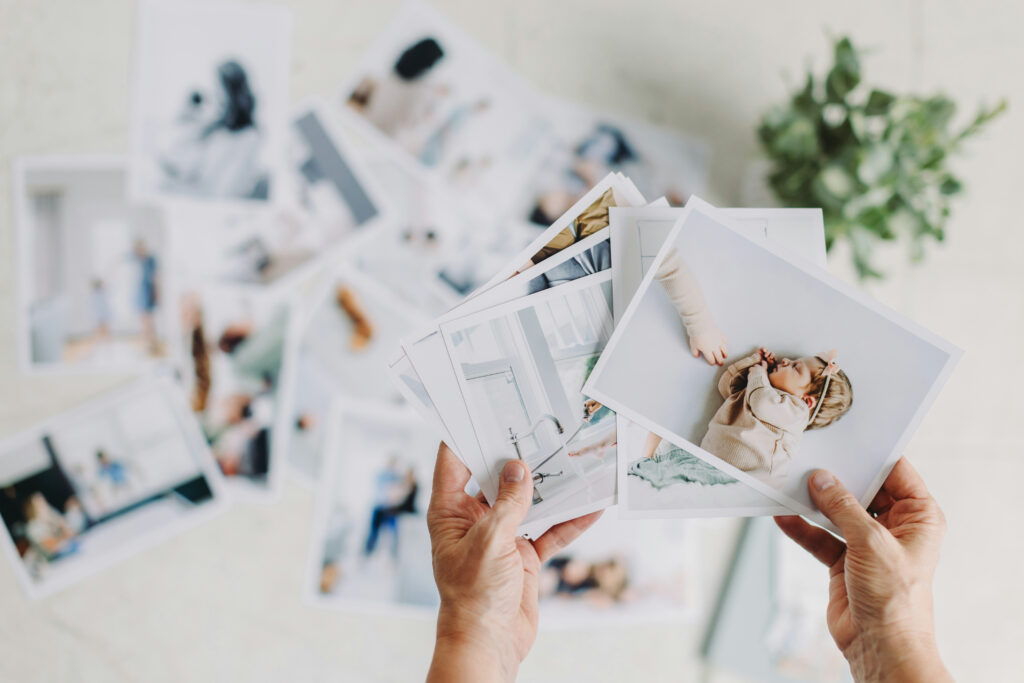 What to Expect After Your Photo Session: A Step-by-Step Guide - NPS Photography Hands hold printed family photos, representing what to expect after your photo session when it's time to choose and enjoy your favorite images as keepsakes.