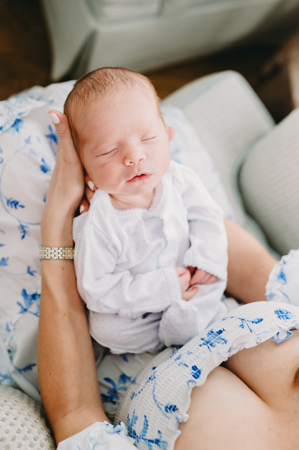 A peacefully sleeping newborn rests in a parent's arms, highlighting the calm beauty of early sessions and why it matters when to book a newborn photographer.