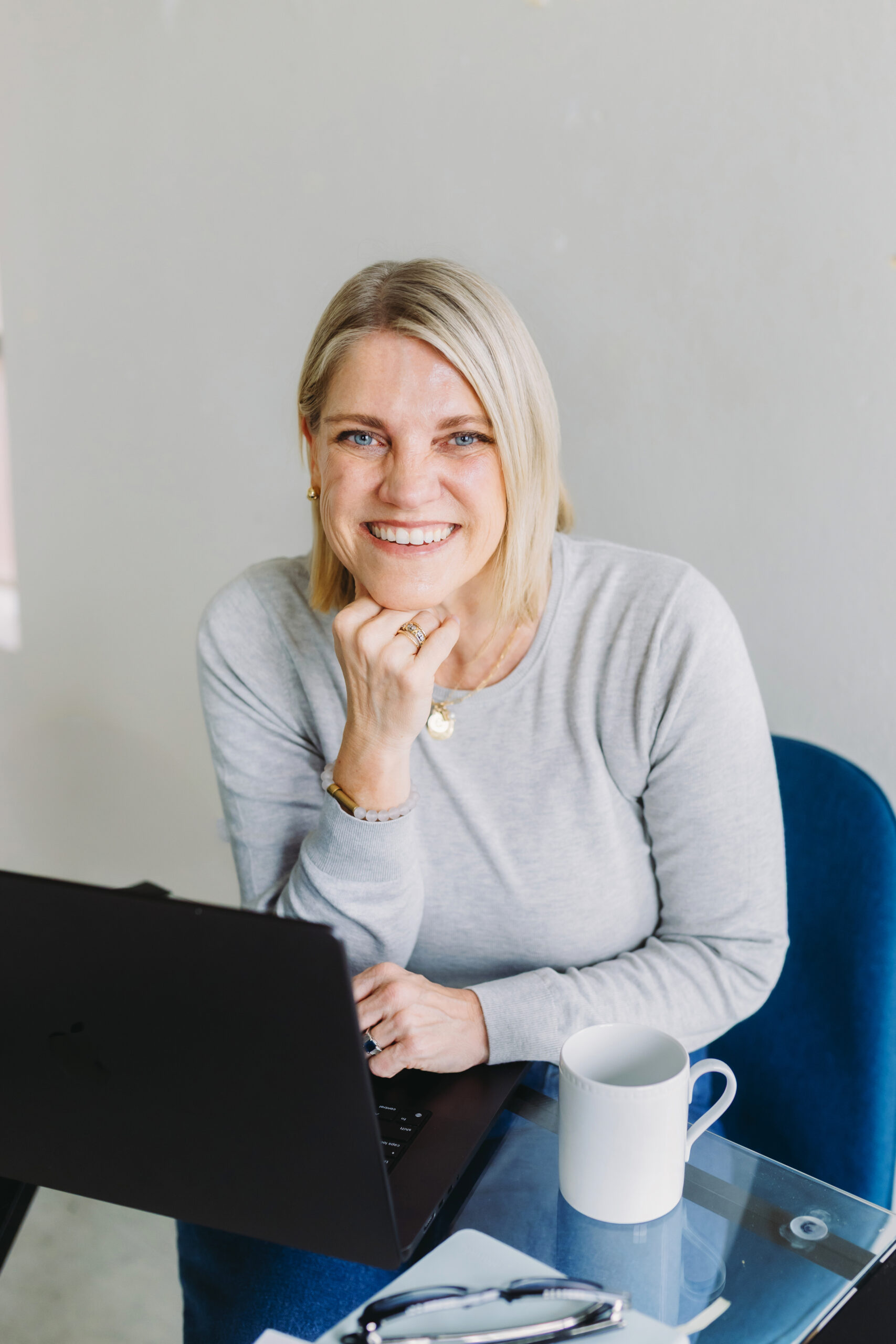 What’s the Best CRM for Photographers? Here’s My 2025 Review - NPS Photography Photographer at her desk with a laptop and coffee, representing a relaxed and organized workflow using the best CRM for photographers.
