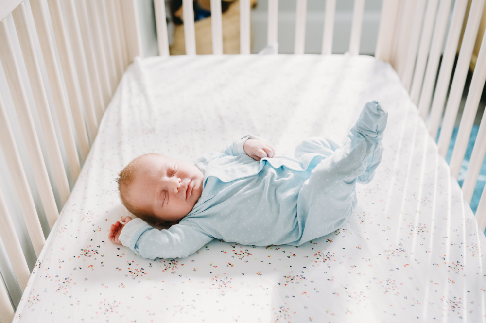 Why Full-Service Family Photography Is Worth Every Penny (And Then Some) - NPS Photography Close-up of a newborn in cozy blue knits, photographed during an in-home full-service family photography session.