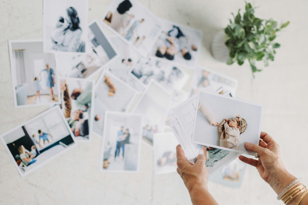 Hands holding printed photographs, showcasing the result of using systems to simplify your photography business workflow.