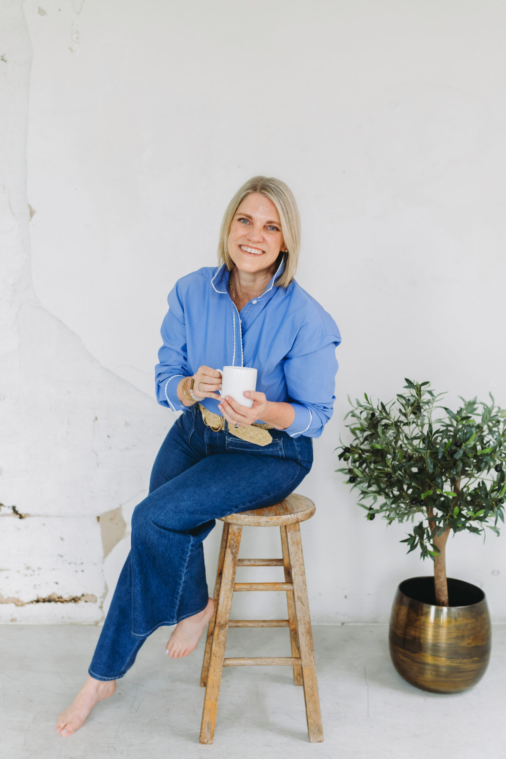 Photographer sitting barefoot with coffee, embodying the ease and balance that comes when you simplify your photography business.