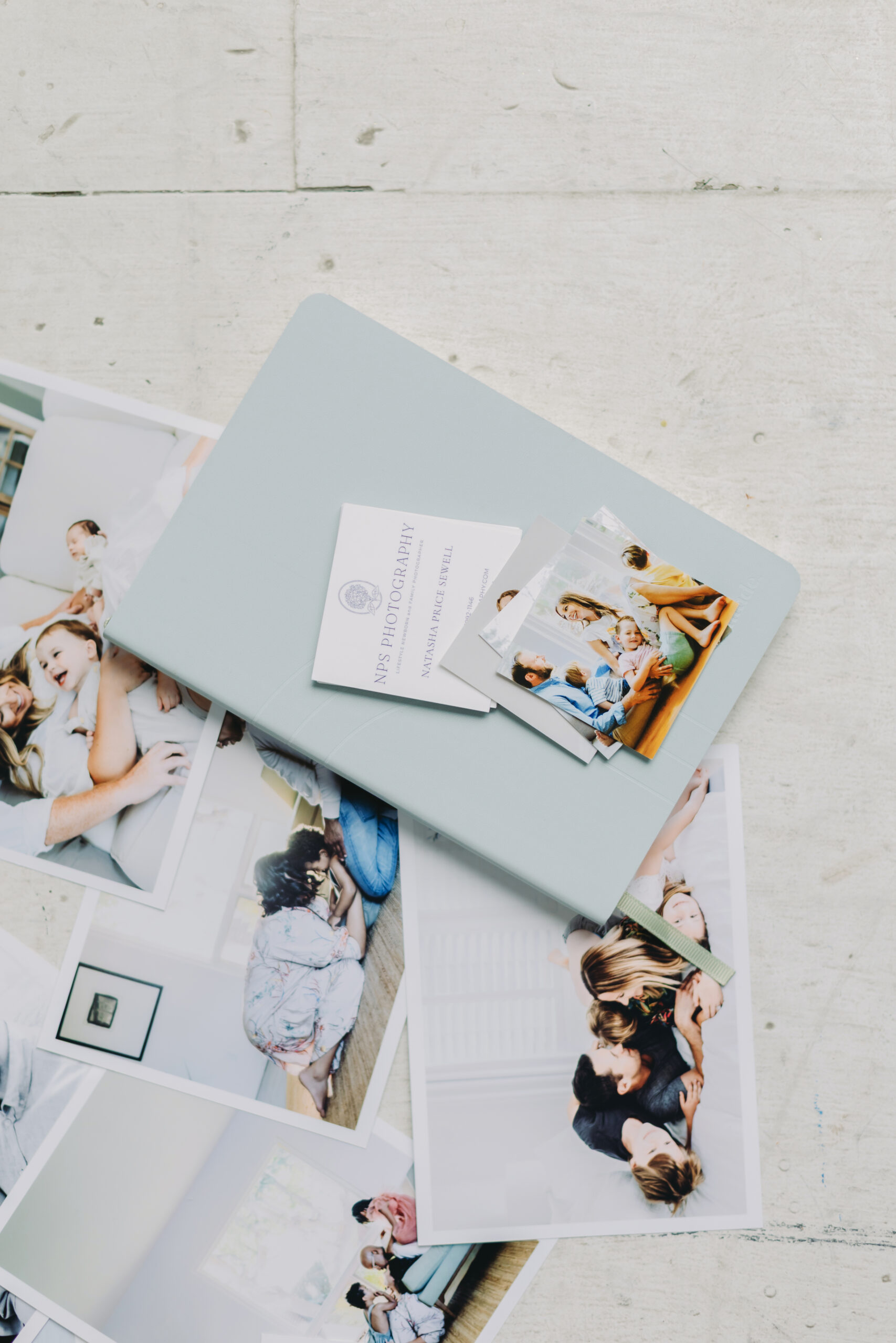 Family Photo Gift Ideas Your Loved Ones Will Treasure This Holiday Season - NPS Photography Heirloom photo album surrounded by printed family portraits, representing timeless family photo gift ideas for loved ones.