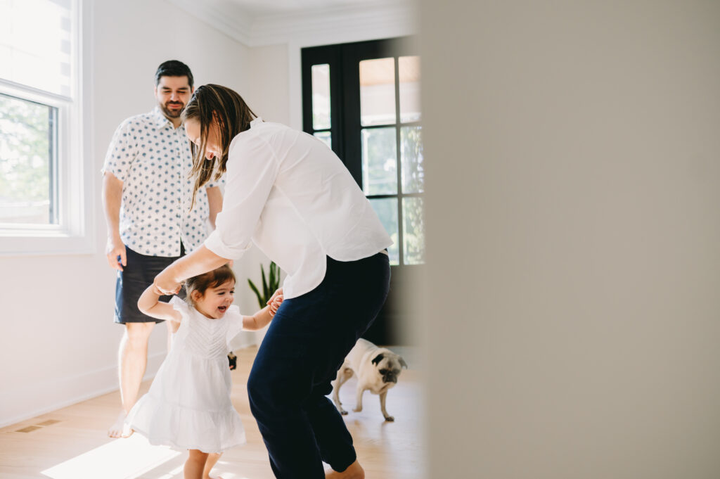 What Is Storytelling Photography? The Heartfelt Secret to Capturing Your Family’s Most Meaningful Moments - NPS Photography A mother twirls her giggling toddler as sunlight fills their home, capturing the pure joy of an ordinary moment together.