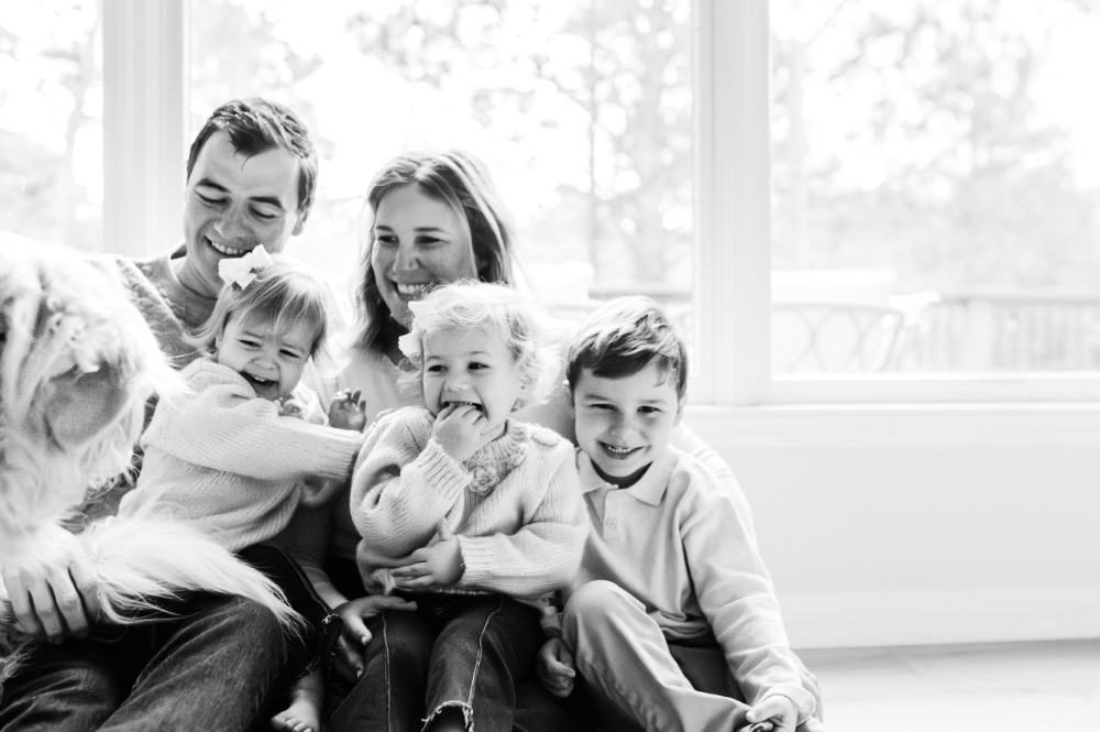 What Is Storytelling Photography? The Heartfelt Secret to Capturing Your Family’s Most Meaningful Moments - NPS Photography A black-and-white scene of three siblings laughing with their parents as their dog bounds into the frame — what is storytelling photography at its most joyful and unscripted.