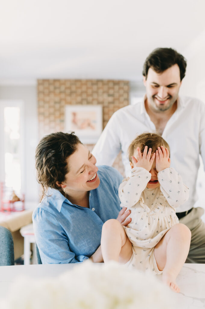 mom and dad with little girl playing peek-a-boo family photo session tips