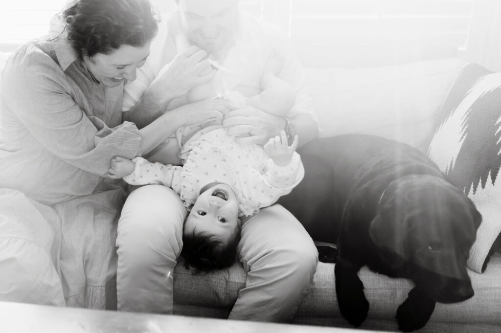 black and white photo of little girl and black lab with mom and dad Family photo session tips 