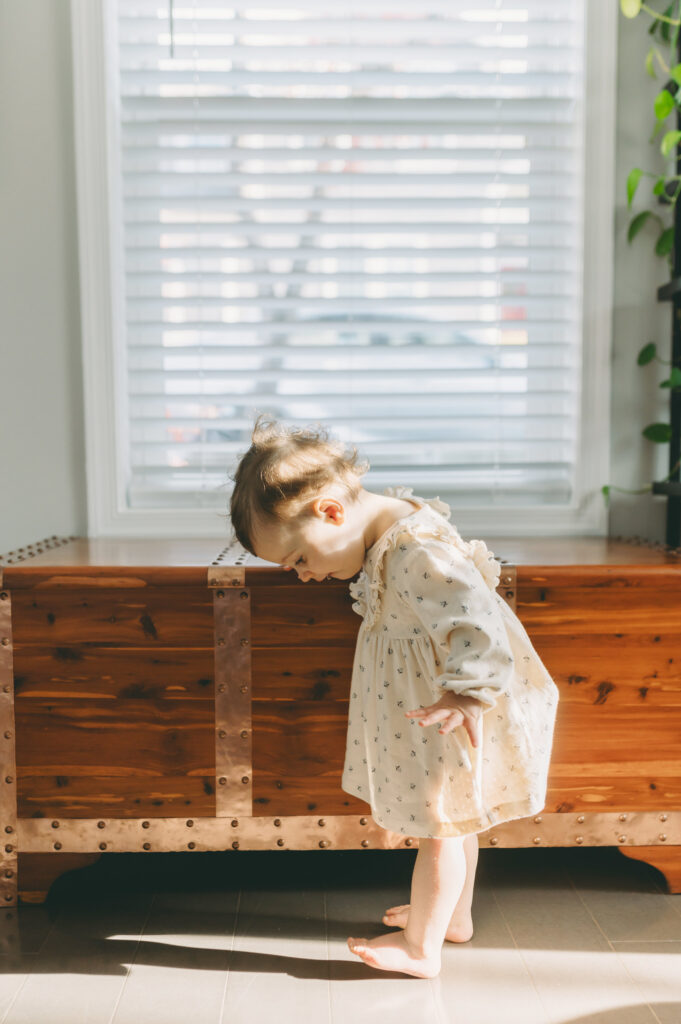 little girl standing in direct light in their home